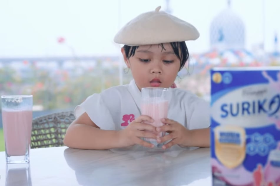 Mit Erdbeergeschmack: Ein Kind nimmt einen kräftigen Schluck Fischmilch.