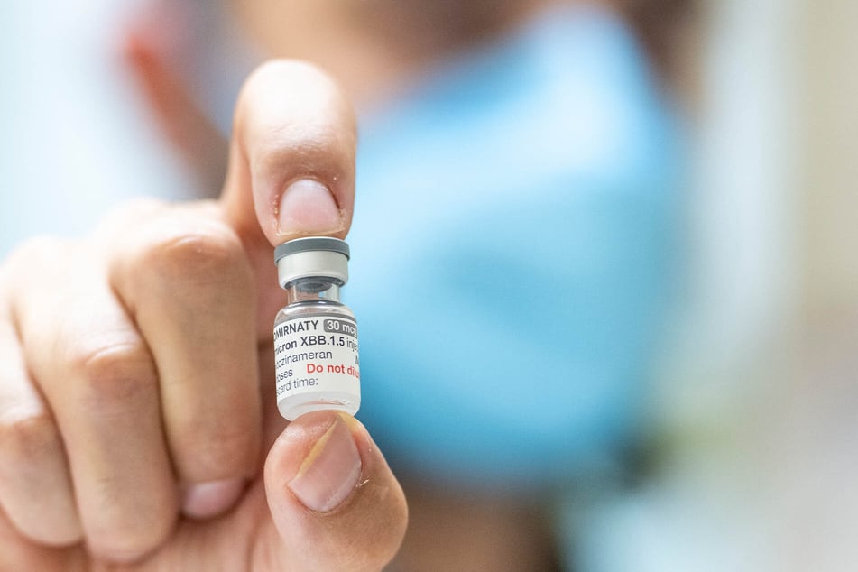 Ein Apotheker hält eine Ampulle mit sechs Dosen des neuen an die Omikron-Sublinie XBB.1.5 angepassten Corona-Impfstoffs.