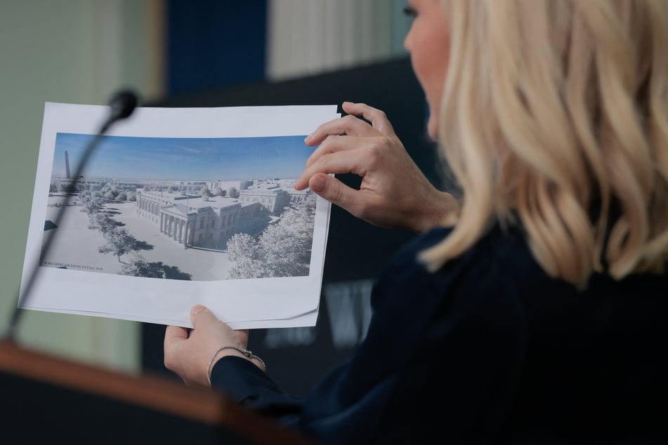 White House Press Secretary Karoline Leavitt holds a rendering of a ballroom building President Donald Trump wants to build during a press briefing on July 31, 2025.