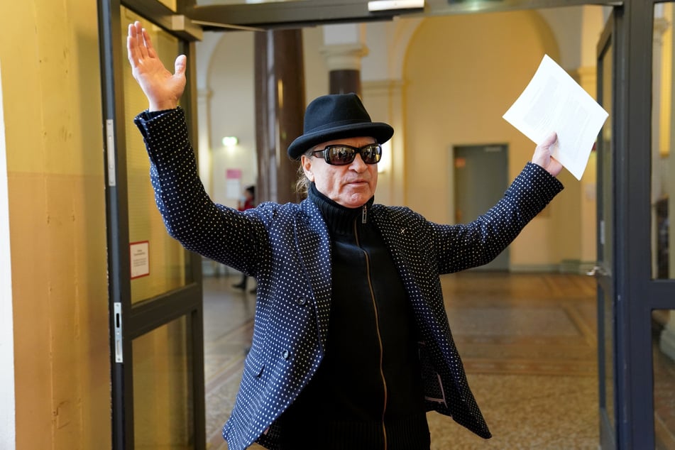 Der Angeklagte Klaus Barkowsky (68) geht mit Hut und Sonnenbrille, aber ohne Maske, zu seinem Berufungsprozess.