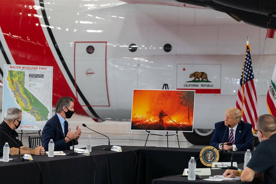 Donald Trump listening as California Governor Gavin Newsom talks about the forest fires in the West during a meeting at Sacramento's McClellan Airport.