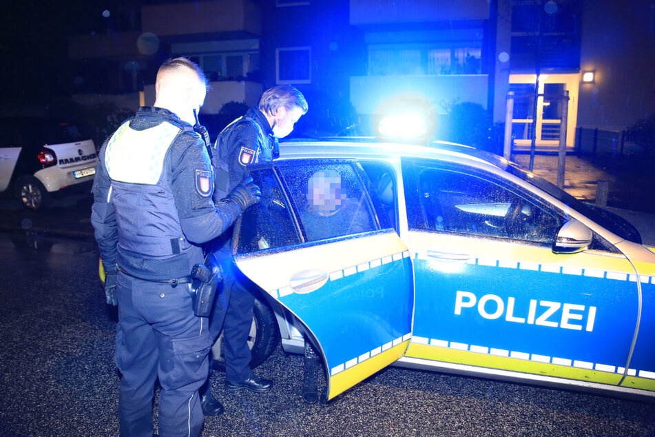 Polizisten führten die Tatverdächtige in Handschellen ab und brachten sie auf die Wache.