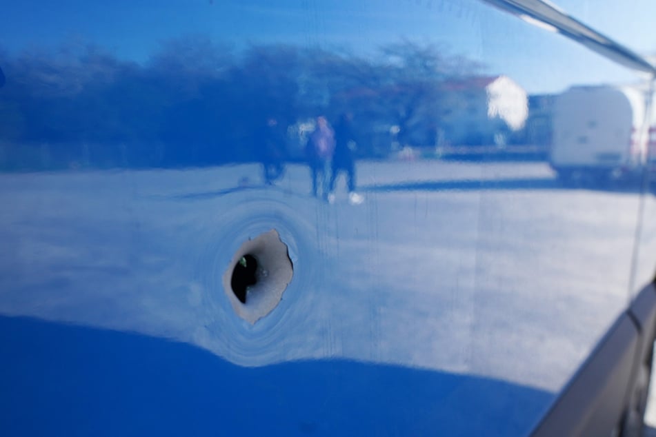 Ein Einschussloch an einem Auto am Tatort.