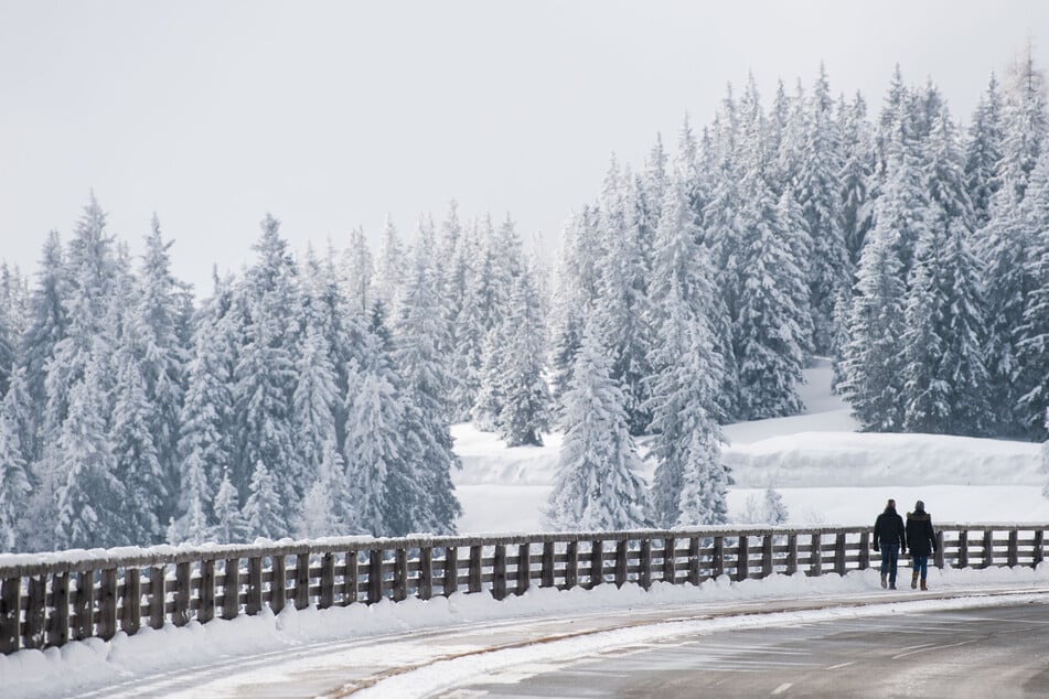 Ein Paar geht an der Rossfeld Panoramastraße an der deutsch-österreichischen Grenze entlang. Die Strecke ist bei jungen Driftern sehr beliebt.