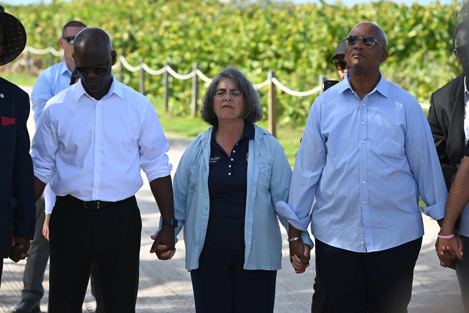 Miami-Dade County Mayor Daniella Levine Cava (c.) and Commissioner Oliver G. Gilbert (r.) during a prayer vigil on the beach as family members remain missing.