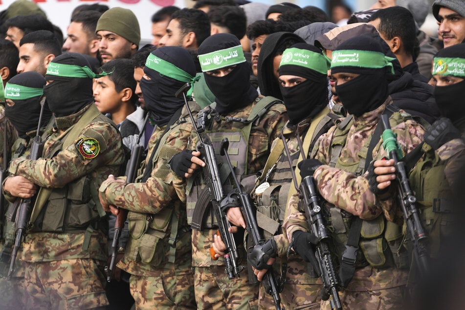 Hamas-Kämpfer stehen in Formation vor der Freilassung von Geiseln im zentralen Gazastreifen.