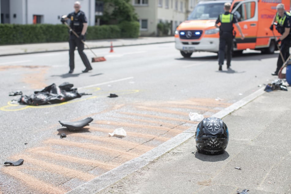Trümmerteile und der Helm der Motorradfahrerin liegen am Unfallort.