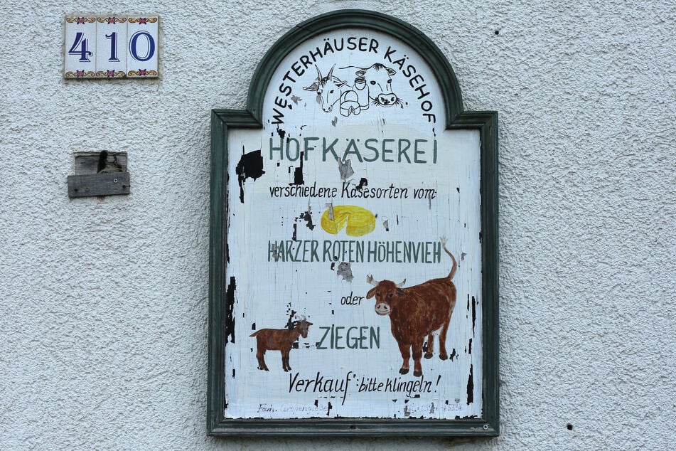 Eine Hinweistafel gibt Auskunft über das Angebot der Hofkäserei im Harz. Hier werden jährlich bis zu 3 Tonnen Käse verschiedener Sorten, darunter auch Harzkäse produziert.