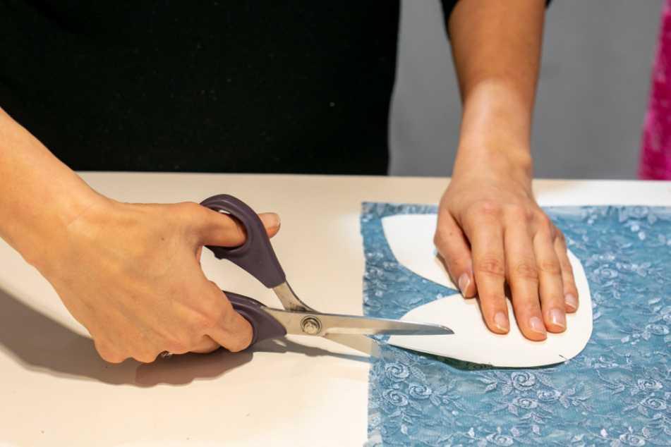 Statt Ballkleider werden Masken aus dem Spitzenstoff geschnitten.