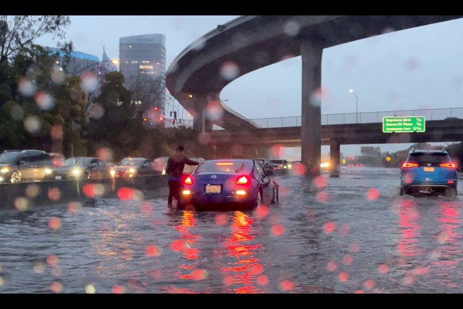 Vehicles make their way through flooded roads after heavy rains in San Francisco, California, on December 31, 2022.