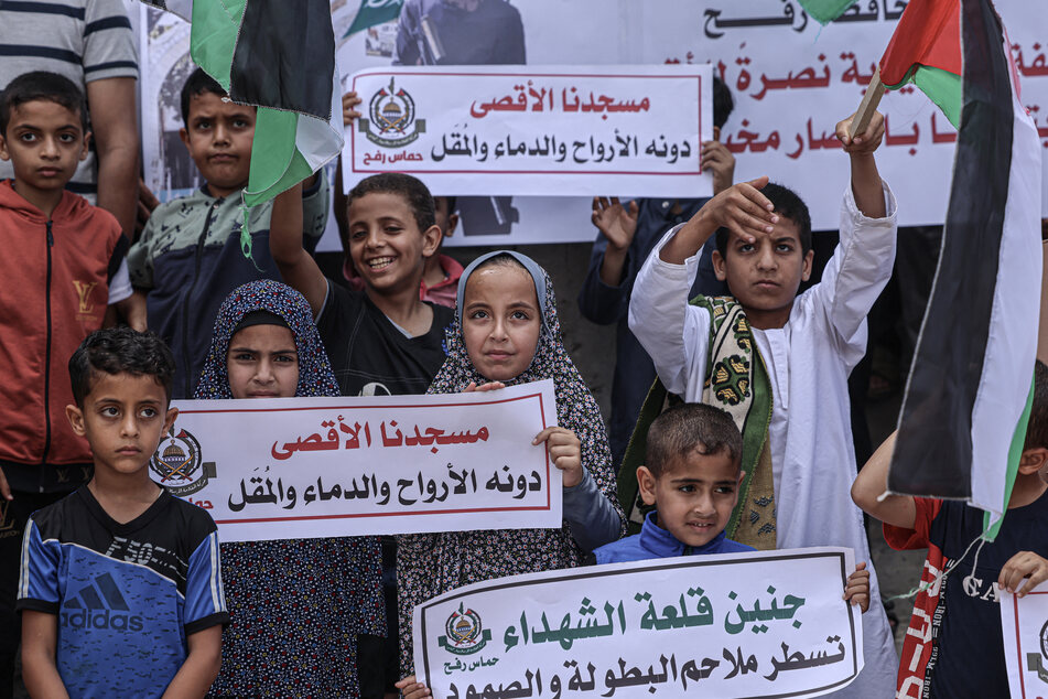 Hamas supporters pose children with pro-Hamas signs on July 7, 2023, in Rafah in the southern Gaza Strip.