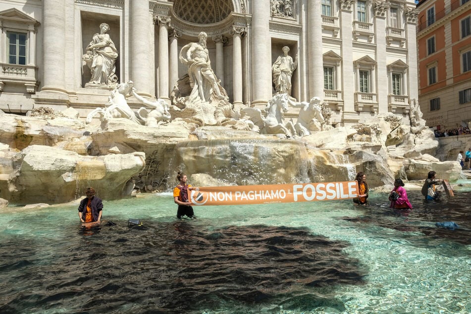 Die Umweltschützer bei der Protestaktion im Trevi-Brunnen.