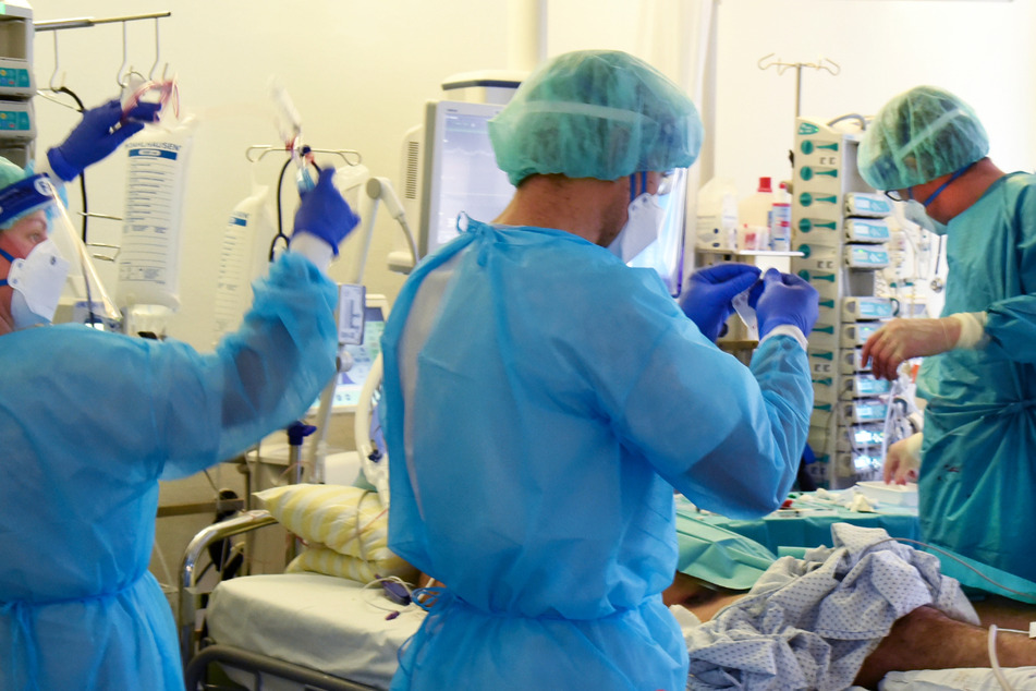 In einer Intensivstation versorgen Mediziner einen Covid-19-Patienten – die vierte Welle der Coronavirus-Pandemie dauert in Hessen weiterhin an.