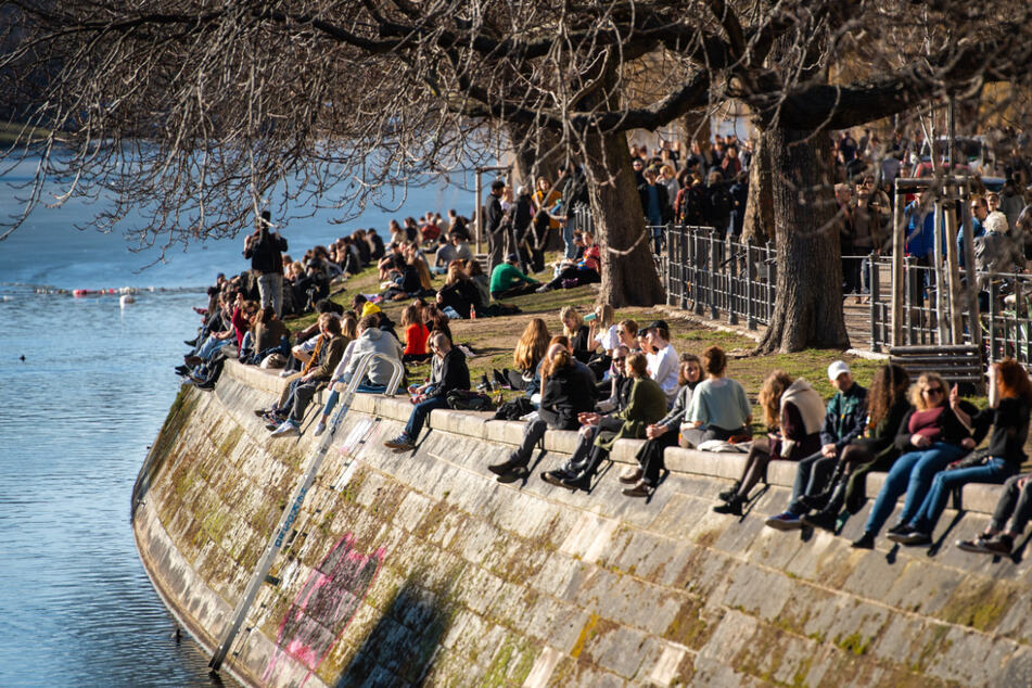 Menschen genießen am Landwehrkanal in Kreuzberg die Sonne.