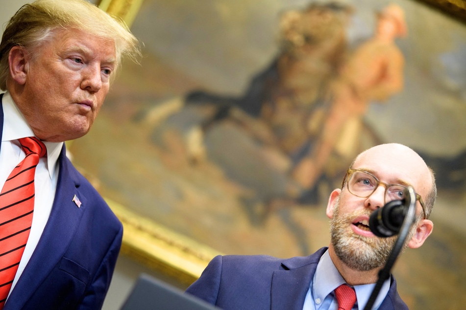 Then-President Donald Trump (l.) listening to OMB Director Russell Vought speak during an executive order signing on federal regulations at the White House on October 9, 2019.