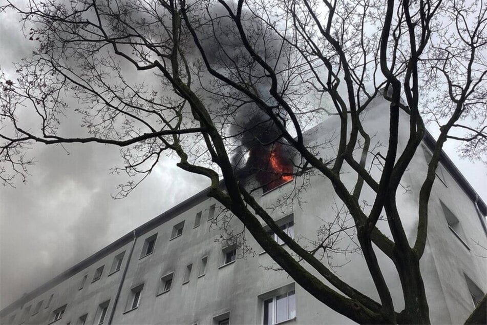 Feuer und Rauch dringen aus der Wohnung in der vierten Etage.