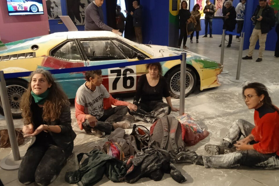 Klima-Aktivistinnen schmeißen kiloweise Mehl auf Auto-Kunstwerk