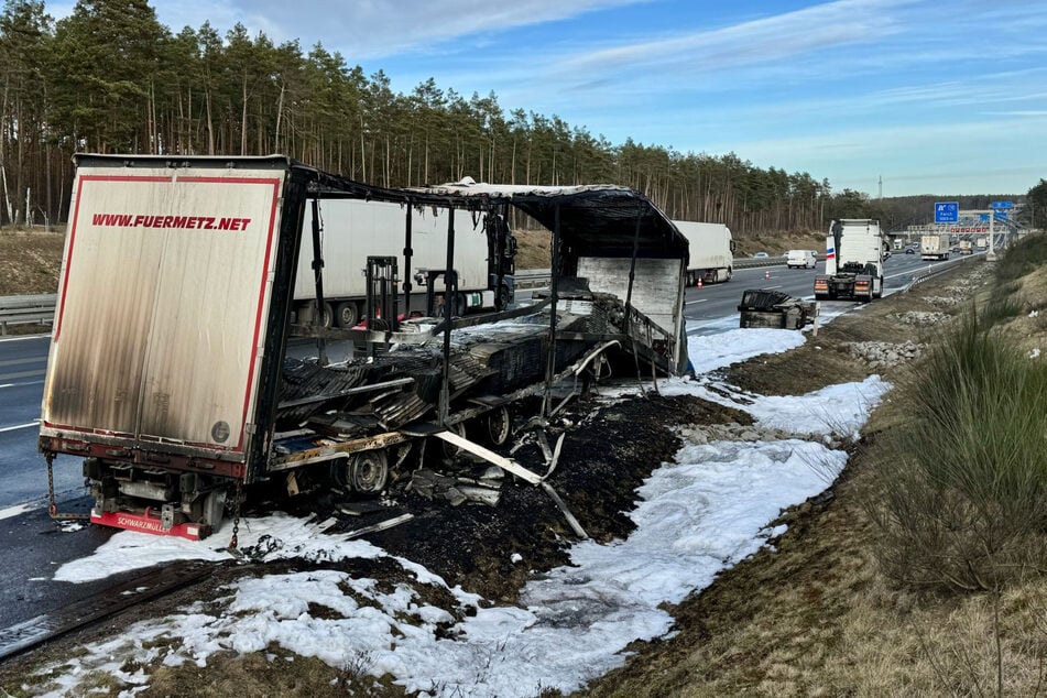 Der LKW-Fahrer schafft es noch, den Sattelzug nach rechts an den Fahrbahnrand zu stellen, ehe der Auflieger komplett ausgebrannt ist.