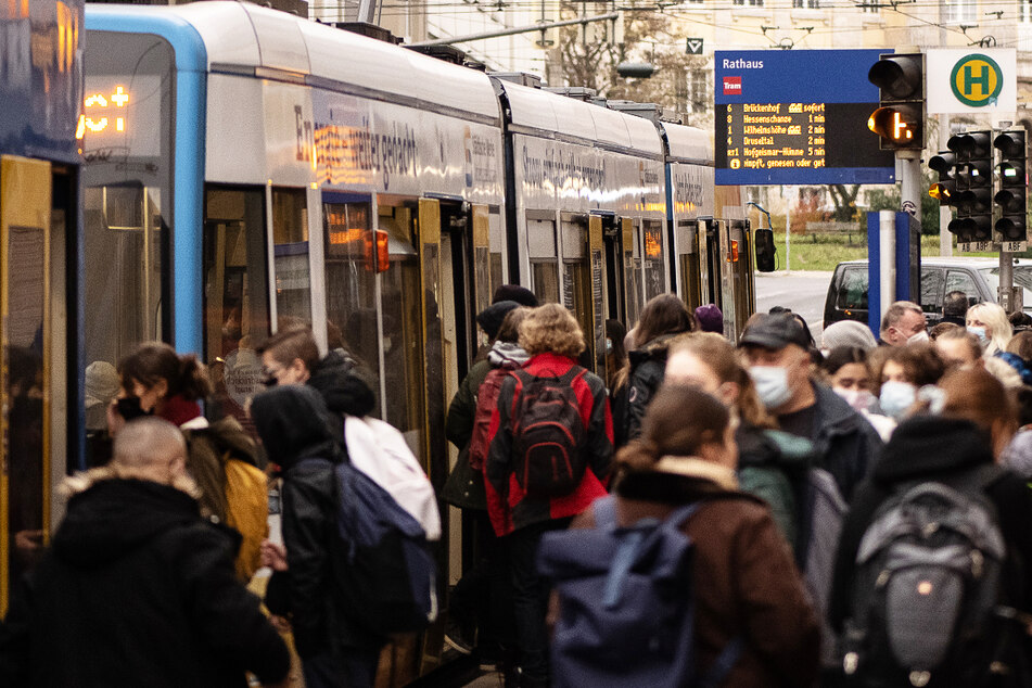 Fahrgäste stehen an einer Haltestelle in Kassel vor einer Straßenbahn – in allen Bussen und Bahnen des NVV gilt seit knapp zwei Wochen die 3G-Regel.