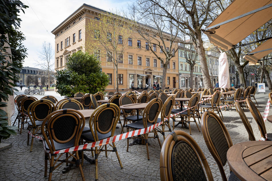 Absperrband ist um die Tische und Stühle vor einem Restaurant in Weimars Innenstadt gezogen. Essen darf nur mitgenommen werden.