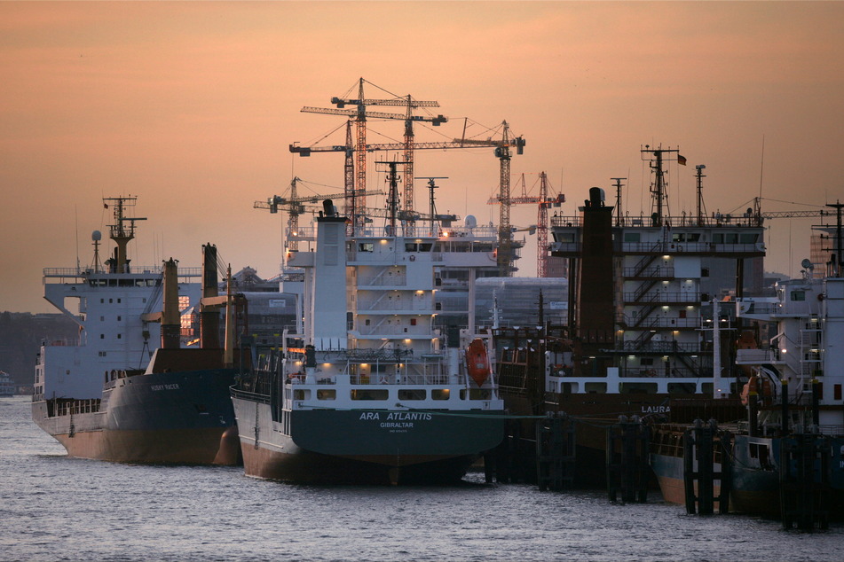 Mehrere leere Containerschiffe liegen im Hafen.