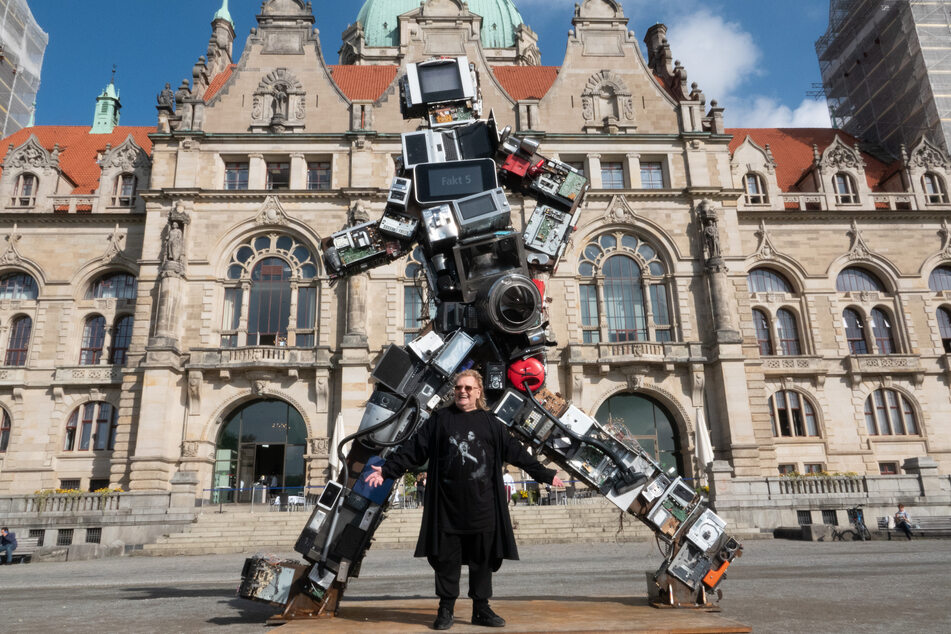 Der Künstler HA Schult (82) vor seiner Skulptur "Wertgigant" aus Schrott in Hannover.