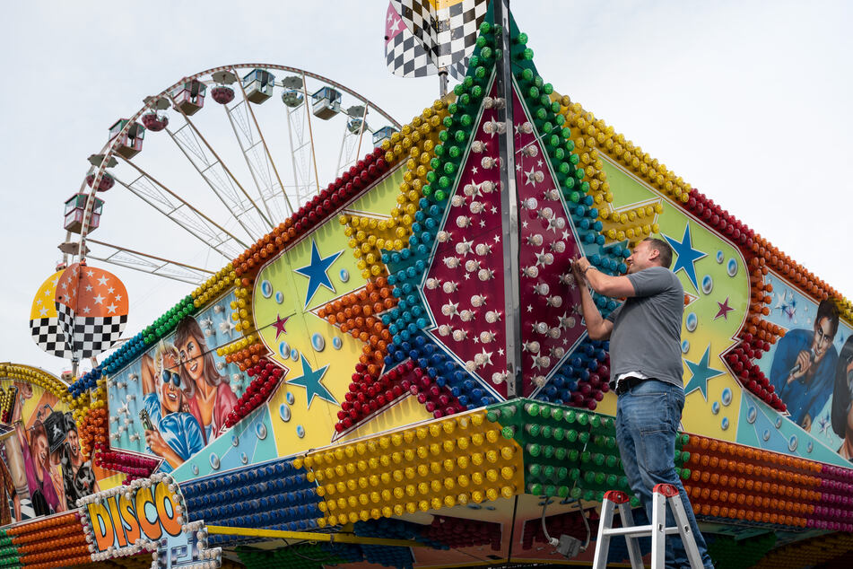 Ein großes Fahrgeschäft und ein nostalgisches Riesenrad "Roue Parisienne" werden vor der Westfalenhalle in Dortmund aufgebaut.
