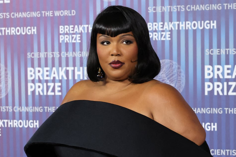 A judge has dismissed harassment claims against Lizzo brought by a former backup dancer, but the singer's touring company will still have to fight the lawsuit.