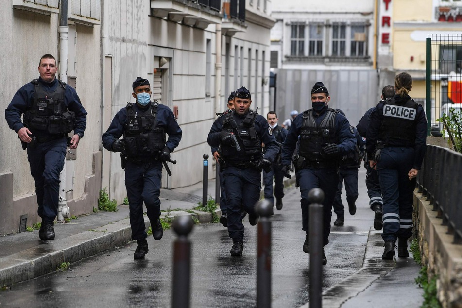 Französische Polizisten eilen zum Tatort, nachdem in der Nähe der ehemaligen Büros des französischen Satiremagazins Charlie Hebdo nach einem angeblichen Angriff eines Mannes mit einem Messer.