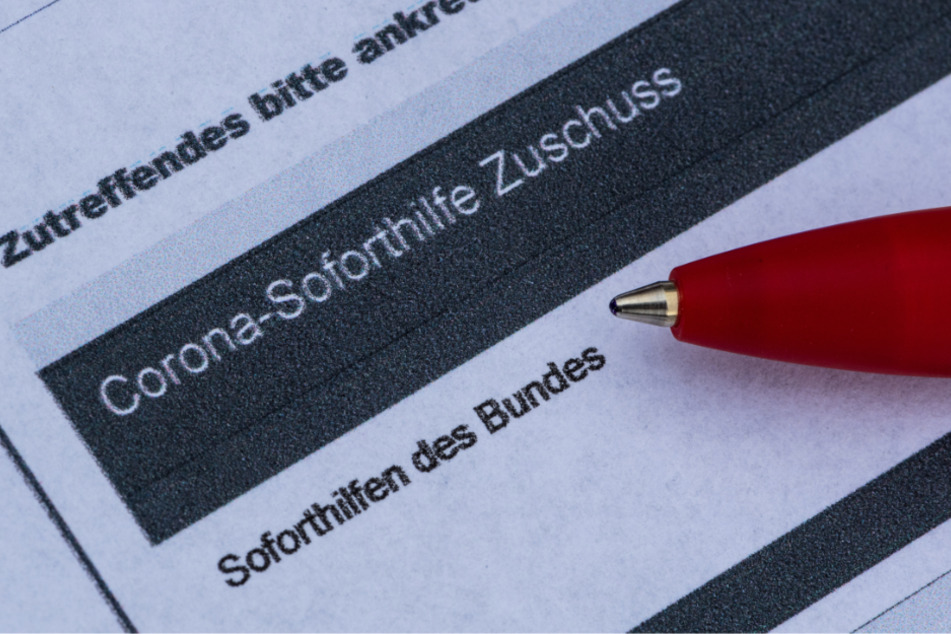 Ein Stift liegt auf einem Antrag für den Corona-Soforthilfe-Zuschuss.