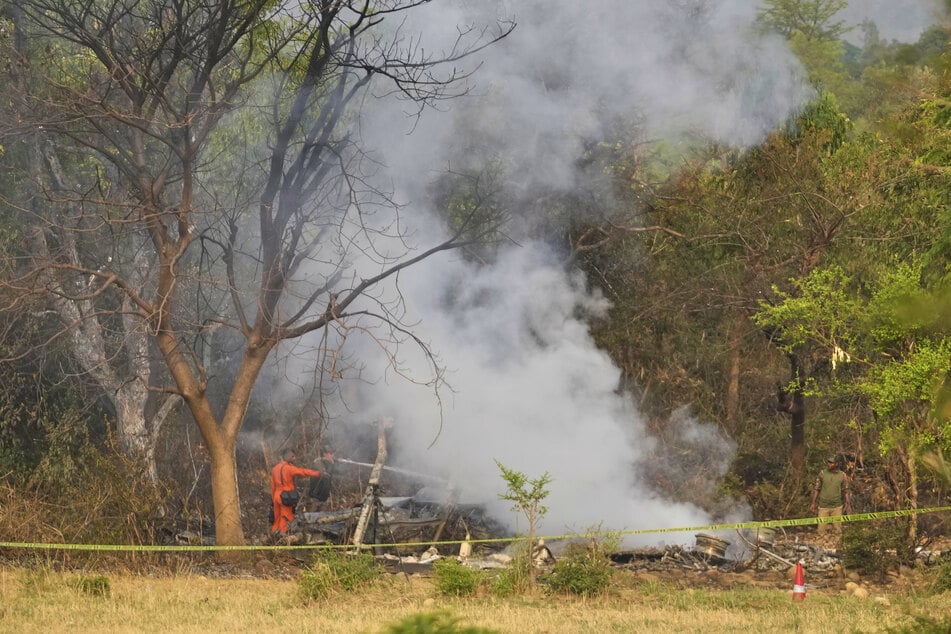Indien: Feuerwehrleute arbeiten gegen Rauch an, der aus den Trümmern eines Flugzeugs am Stadtrand von Jammu aufsteigt.