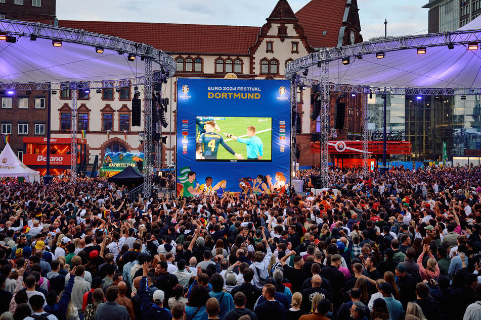 Etliche Besucher verfolgen beim Public Viewing in der Fanzone Dortmund auf dem Friedensplatz ein Spiel der Fußball-EM.