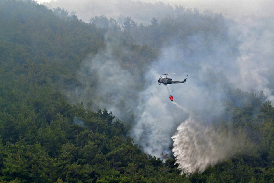 Ein Löschhubschrauber lässt Wasser auf den Waldbrand Batramaz im nördlichen Distrikt Minie-Danniye fallen.