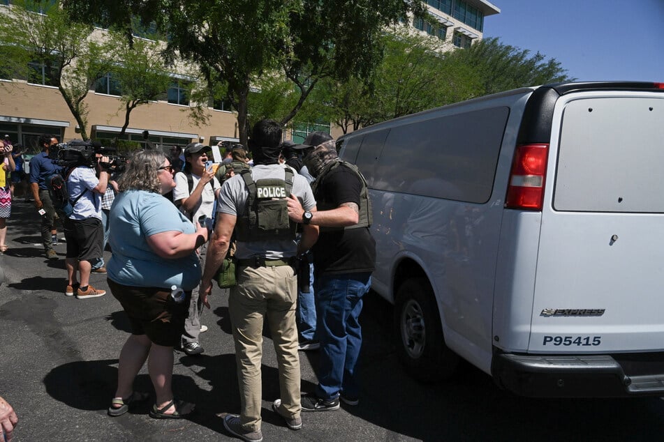 Law enforcement officers, including Homeland Security Investigations and ICE agents, take people into custody at an immigration court in Phoenix, Arizona, on May 21, 2025.