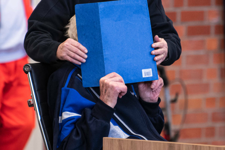 Der 101-jährige Angeklagte will nicht erkannt werden und hält sich einen Hefter vor das Gesicht. Am Mittwoch ist der Prozess gegen den mutmaßlichen Ex-KZ-Wachmann fortgesetzt worden.