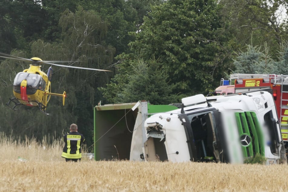 Feuerwehr muss Fahrer befreien: Kies-Laster kommt von Straße ab und kippt um