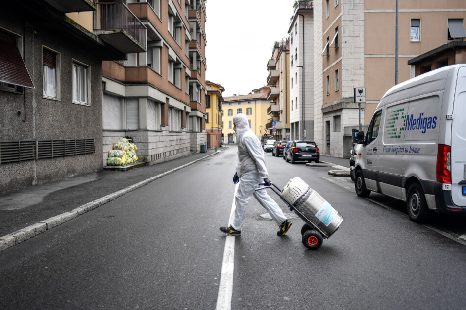 Bergamo: Ein Arbeiter im Schutzanzug liefert eine Sauerstoffflasche an ein Zuhause.