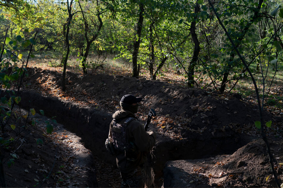 Cherson: Ein ukrainischer Soldat überprüft die von russischen Soldaten ausgehobenen Schützengräben.