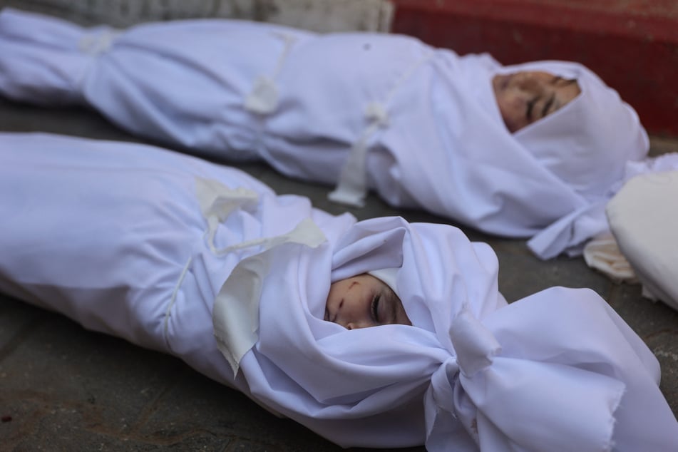 The shrouded bodies of displaced Palestinian children Siwar (top) and Mayar Azam, who were killed in Israeli strikes, lie outside Al-Shifa Hospital in Gaza City on November 20, 2025.
