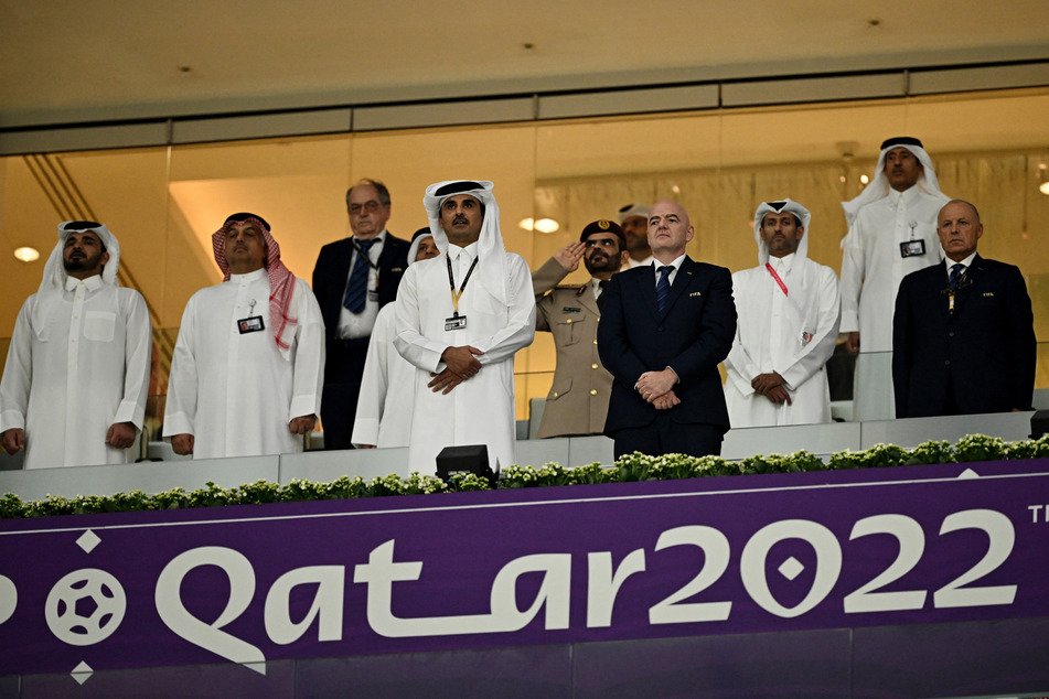 Emir of Qatar Sheikh Tamim bin Hamad Al Thani stands next to FIFA president Gianni Infantino ahead of kick off.