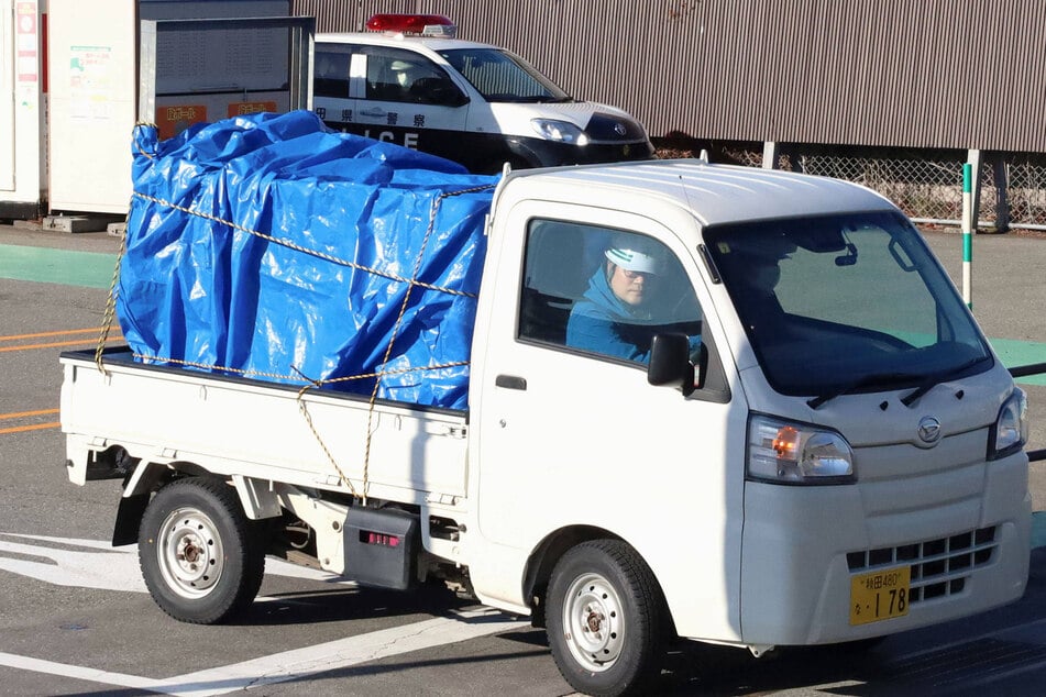 A truck is seen carrying a bear that was trapped and killed after a 3-day standoff in a supermarket is seen leaving the facility in Akita, northeastern Japan, on Dec. 2, 2024. The animal attacked a male employee and ate from the store's meat section, according to police.