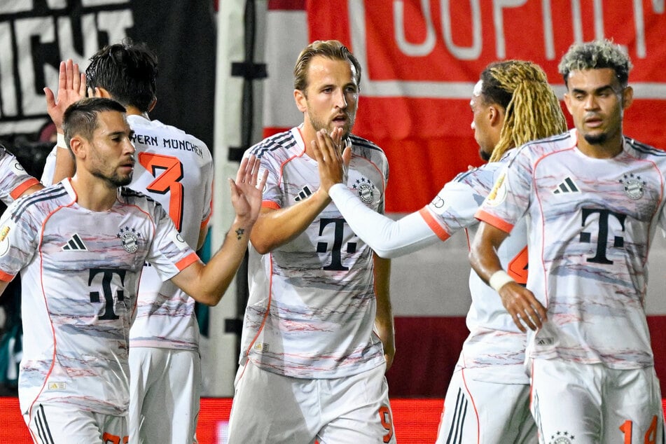 Bayerns Harry Kane (32, Mitte) klatscht nach seinem Tor zur 1:0-Führung mit seinen Teamkollegen ab.