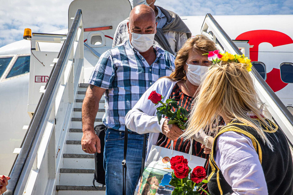 Niederländische Urlauber werden am Flughafen mit Rosen begrüßt. (Archivbild)