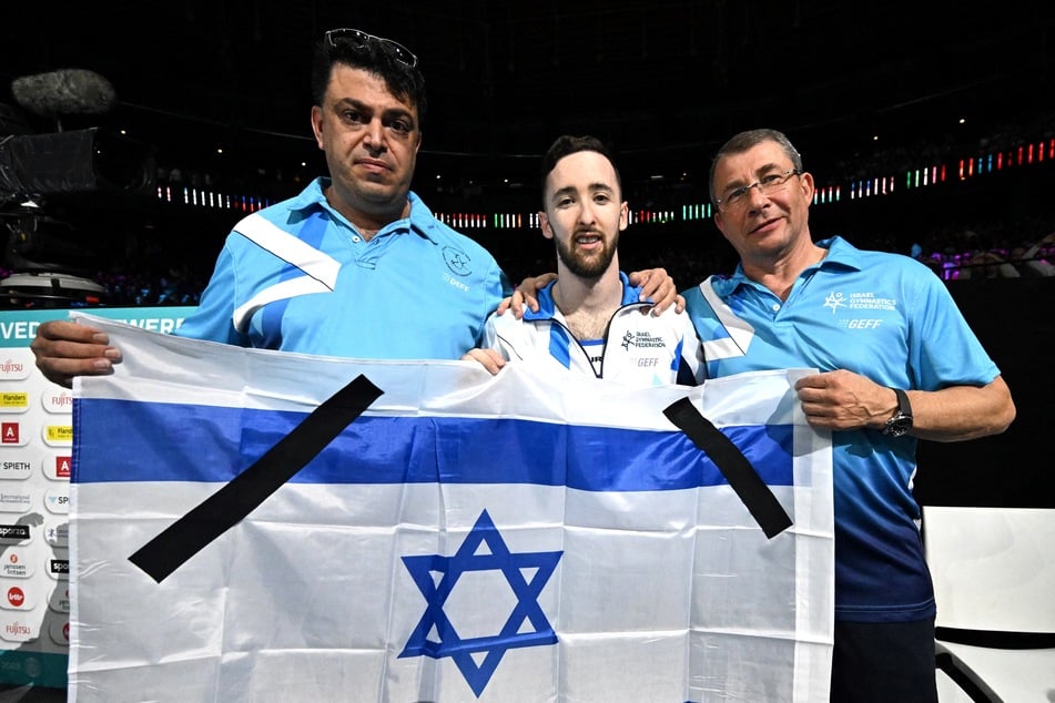 Gut sichtbar brachte Artem Dolgopyat (26, M.) Trauerflore auf der Flagge an, mit der er sein WM-Gold feierte.