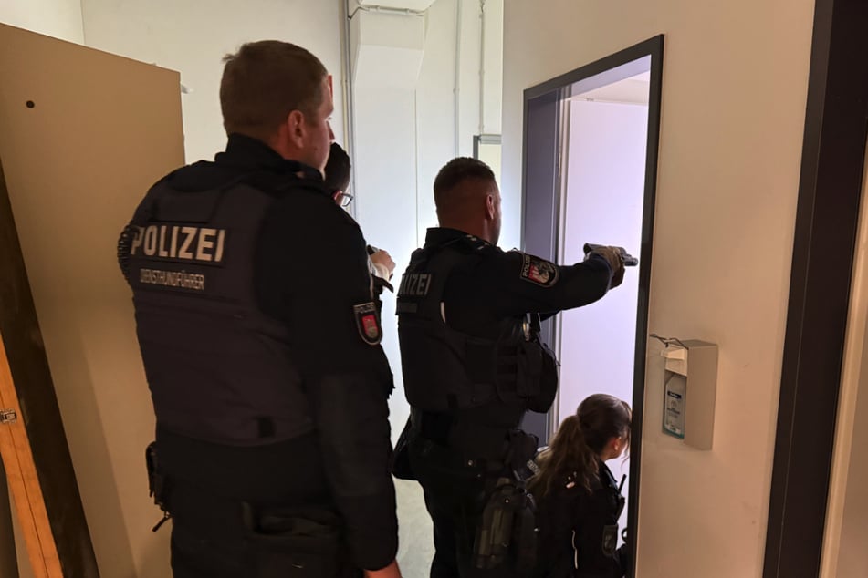 Juno geht voran, gefolgt von den Beamten. Jeder Raum wird durchsucht.