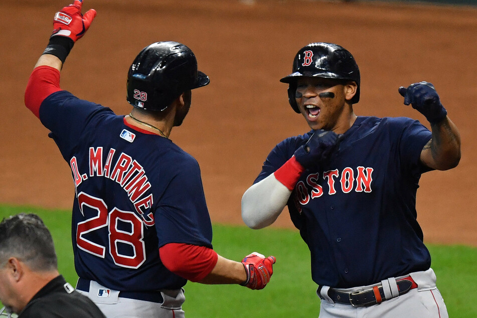 Red Sox designated hitter J.D. Martinez (l) celebrates with Rafael Devers (r) during Boston's game two win on Saturday.