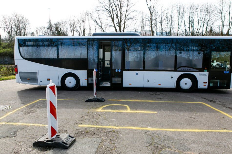 Ein zur mobilen Abstrichstation modifizierter Omnibus steht auf einem Parkplatz.