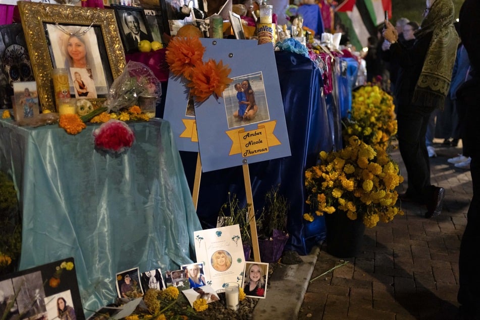 Pictures of women who died due to abortion restrictions are left at a community altar during the 2024 All Souls Procession in Tucson, Arizona on Sunday. The procession, now in its 35th year, brings an average of 150,000 people to the streets of Tucson to walk together in memory of deceased loved ones.