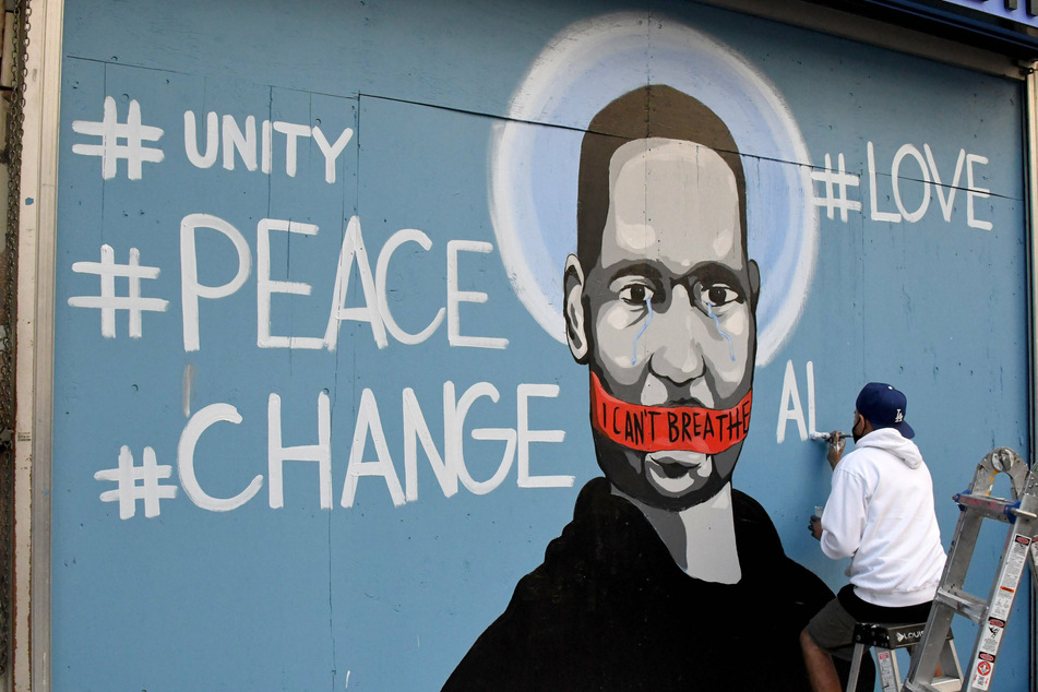 An artist paints a mural of George Floyd (†46) in Los Angeles.