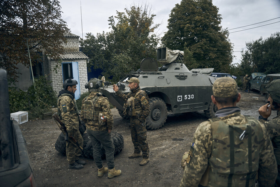 Ukrainische Soldaten auf einer Straße im Stadtgebiet von Izium, in der Region Charkiw, nach dem Abzug russischer Truppen.